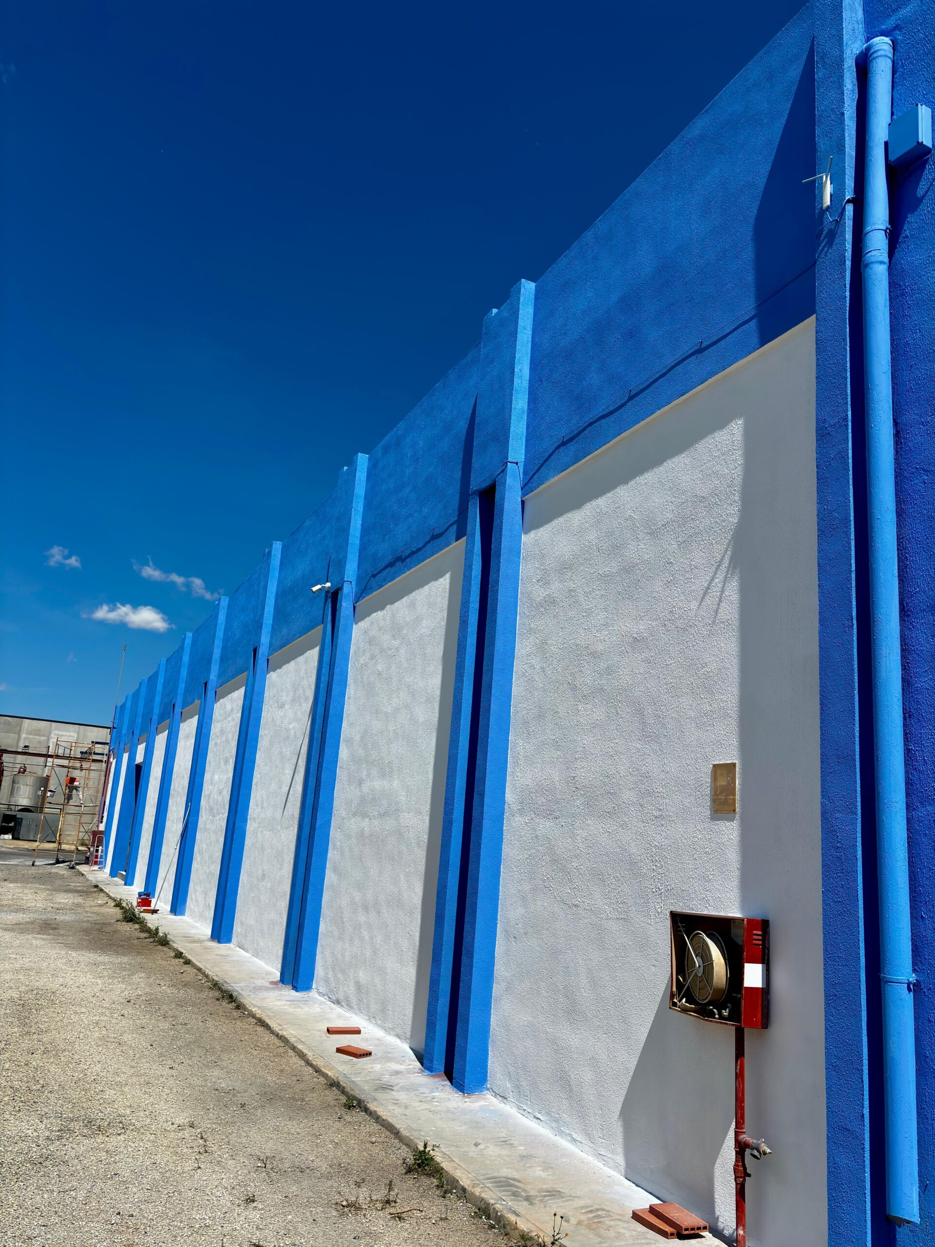 Pintura azul y blanca aplicadas a la nave industrial de Brugués previo a aplicar la rotulación por parte de Proyecta Pintura 5