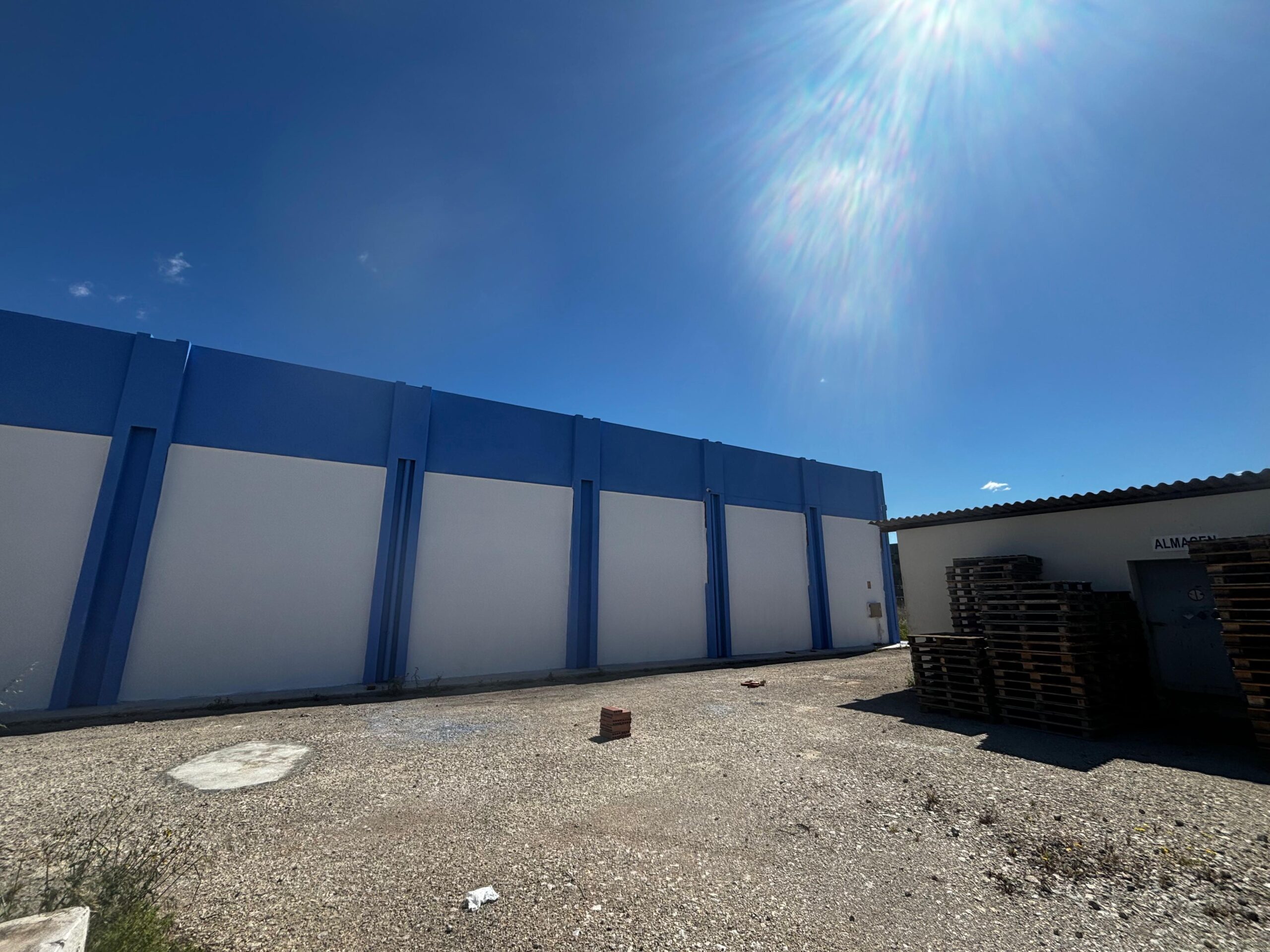 Pintura azul y blanca aplicadas a la nave industrial de Brugués previo a aplicar la rotulación por parte de Proyecta Pintura 1