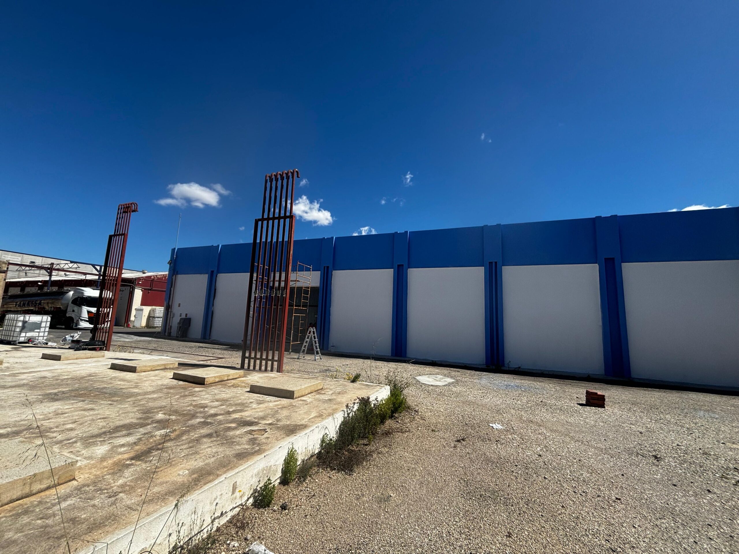 Pintura azul y blanca aplicadas a la nave industrial de Brugués previo a aplicar la rotulación por parte de Proyecta Pintura 2