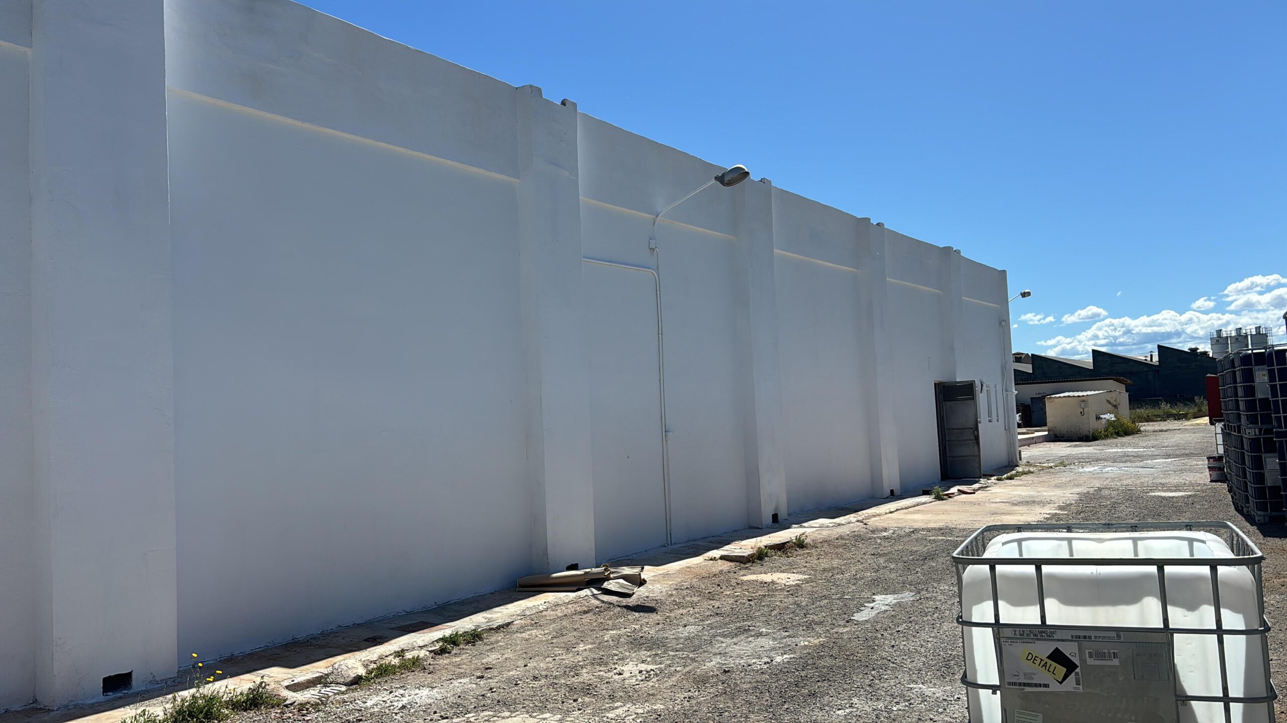 Pintura blanca aplicada a la nave industrial de Brugués previo a aplicar las zonas azules y la rotulación por parte de Proyecta Pintura 1