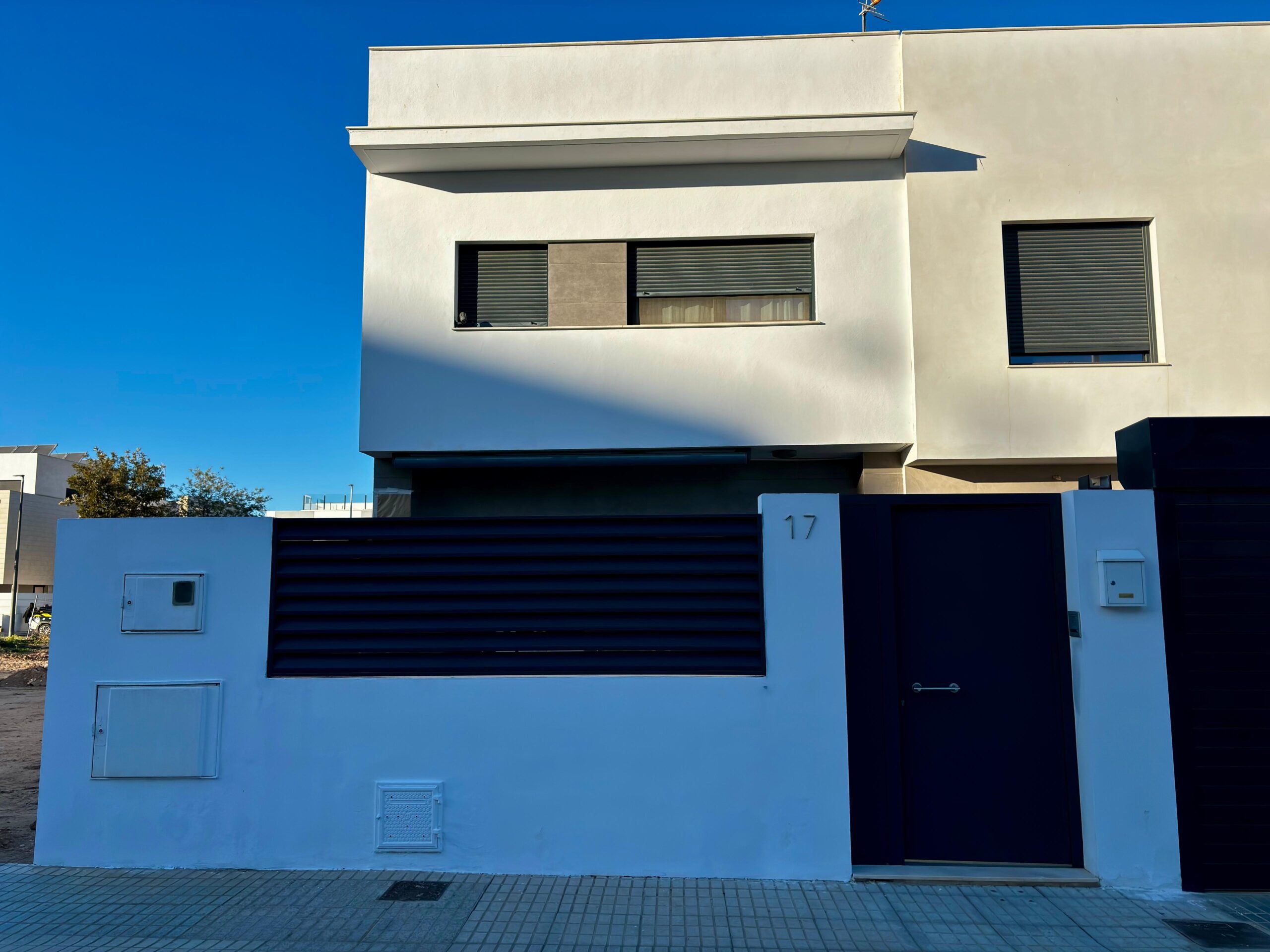 Puerta y vallado metálico acabados tras la rehabilitación de la fachada en Paiporta