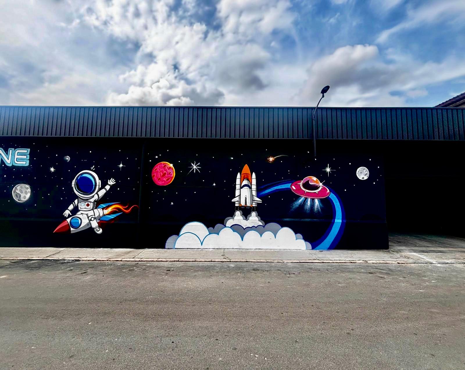 Logotipo de Space Zone Jump rotulado sobre la fachada industrial