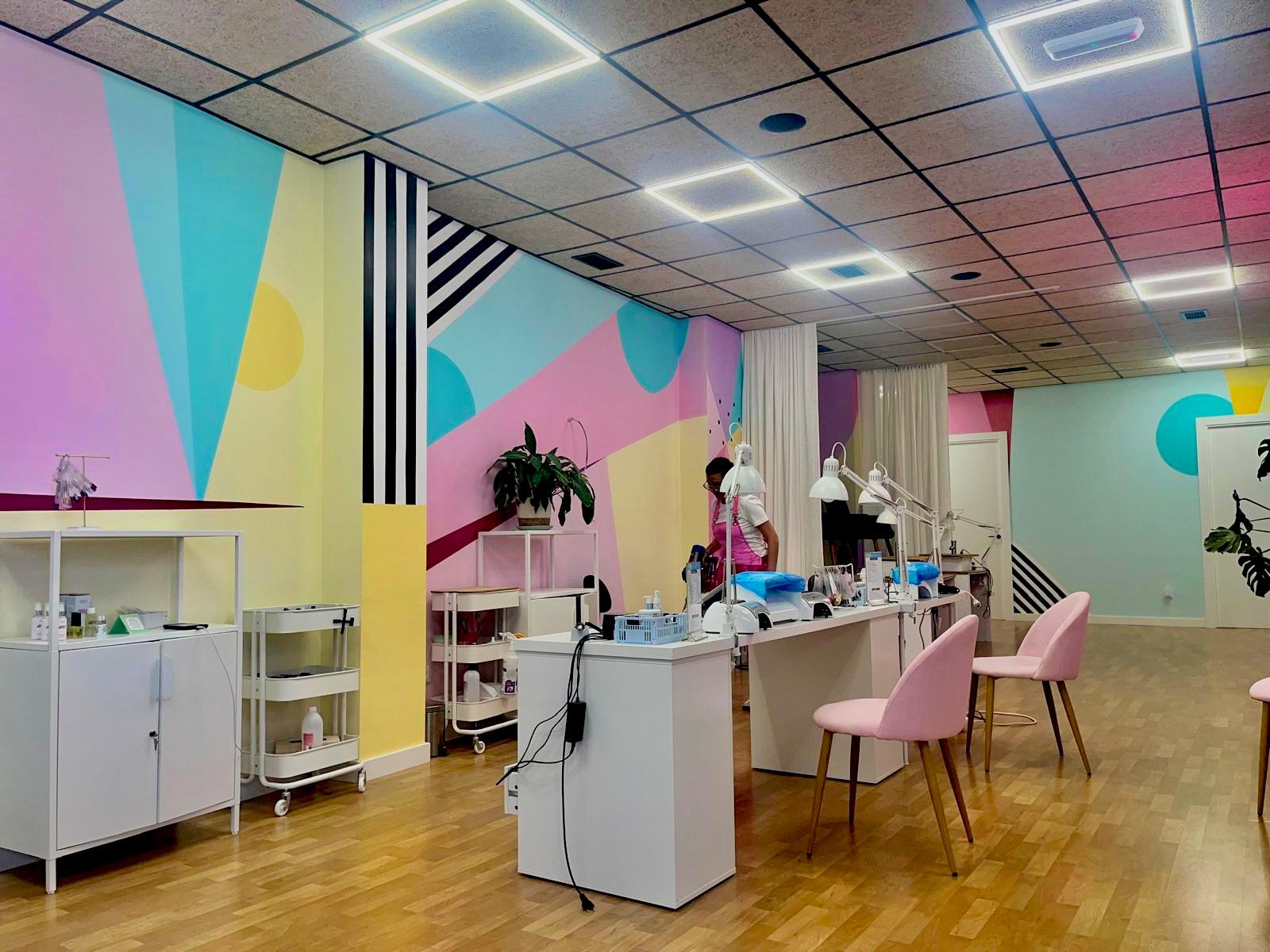 Estaciones de trabajo del centro estético pintadas con murales geométricos pastel