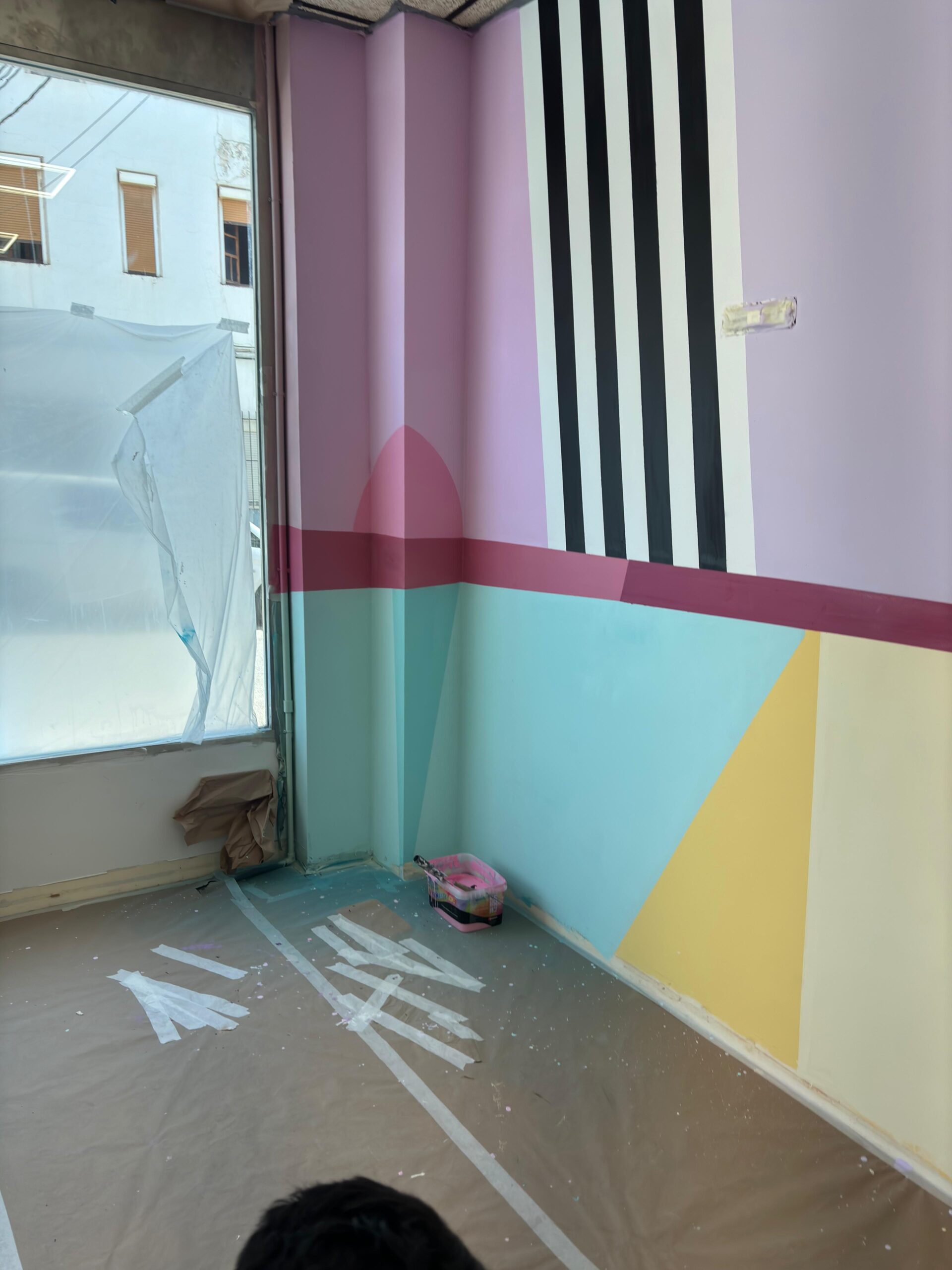 Suelo protegido durante la pintura del mural geométrico en el centro de Beatriz Ruiz